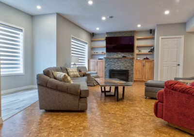 Beautiful Basement renovation with stone fireplace mantel | Versatile Renovations